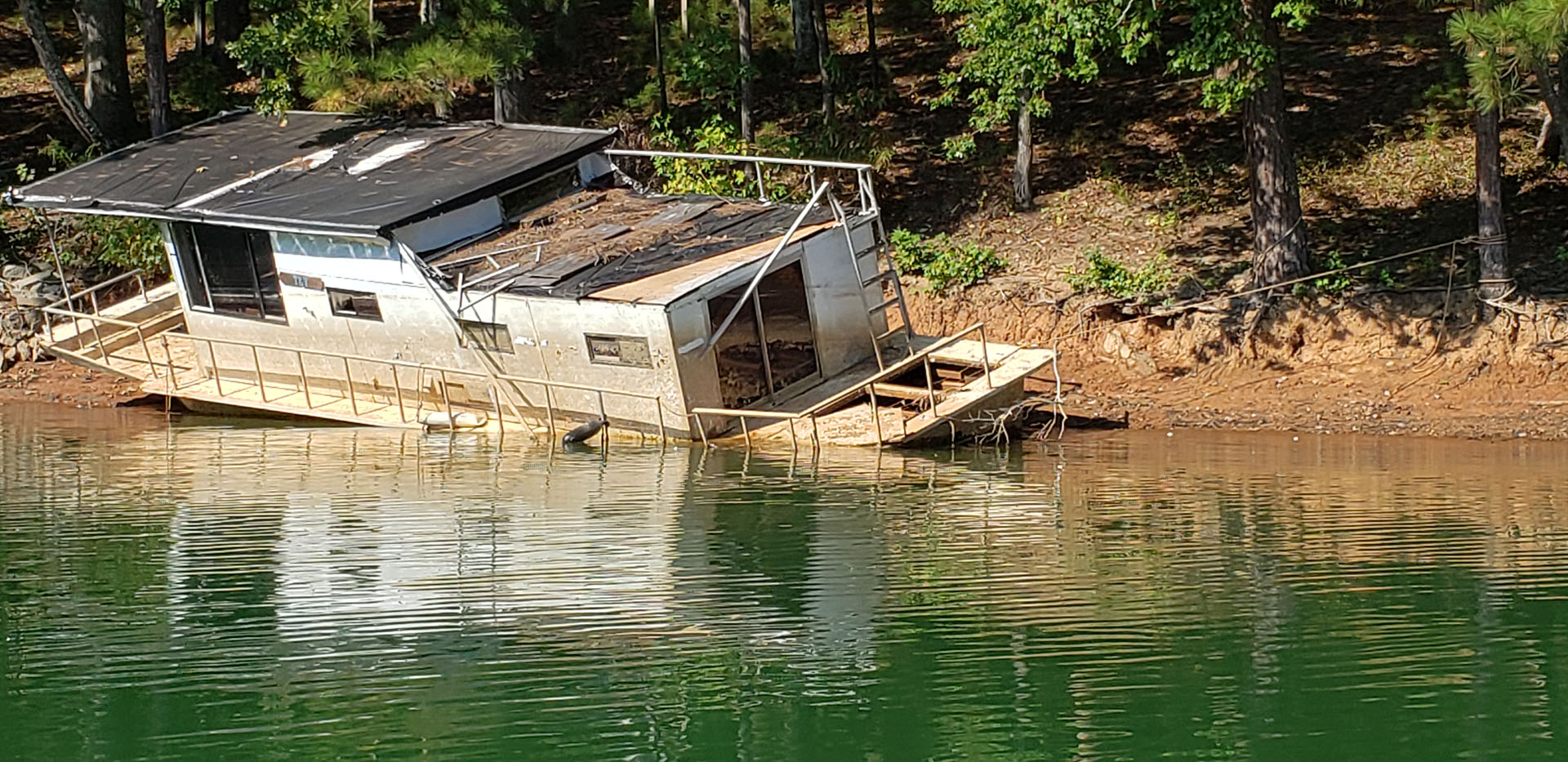 Large boat abandoned on the shore line of Lake Lanier