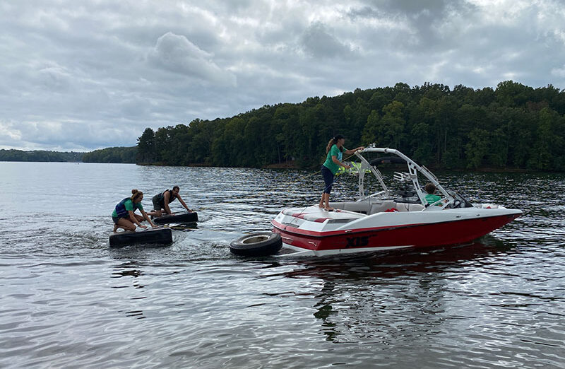 Shore Sweep volunteers removing tires from the lake