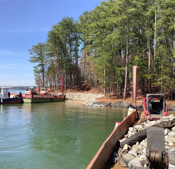 Construction workers on the shore line while using a rip rap technique