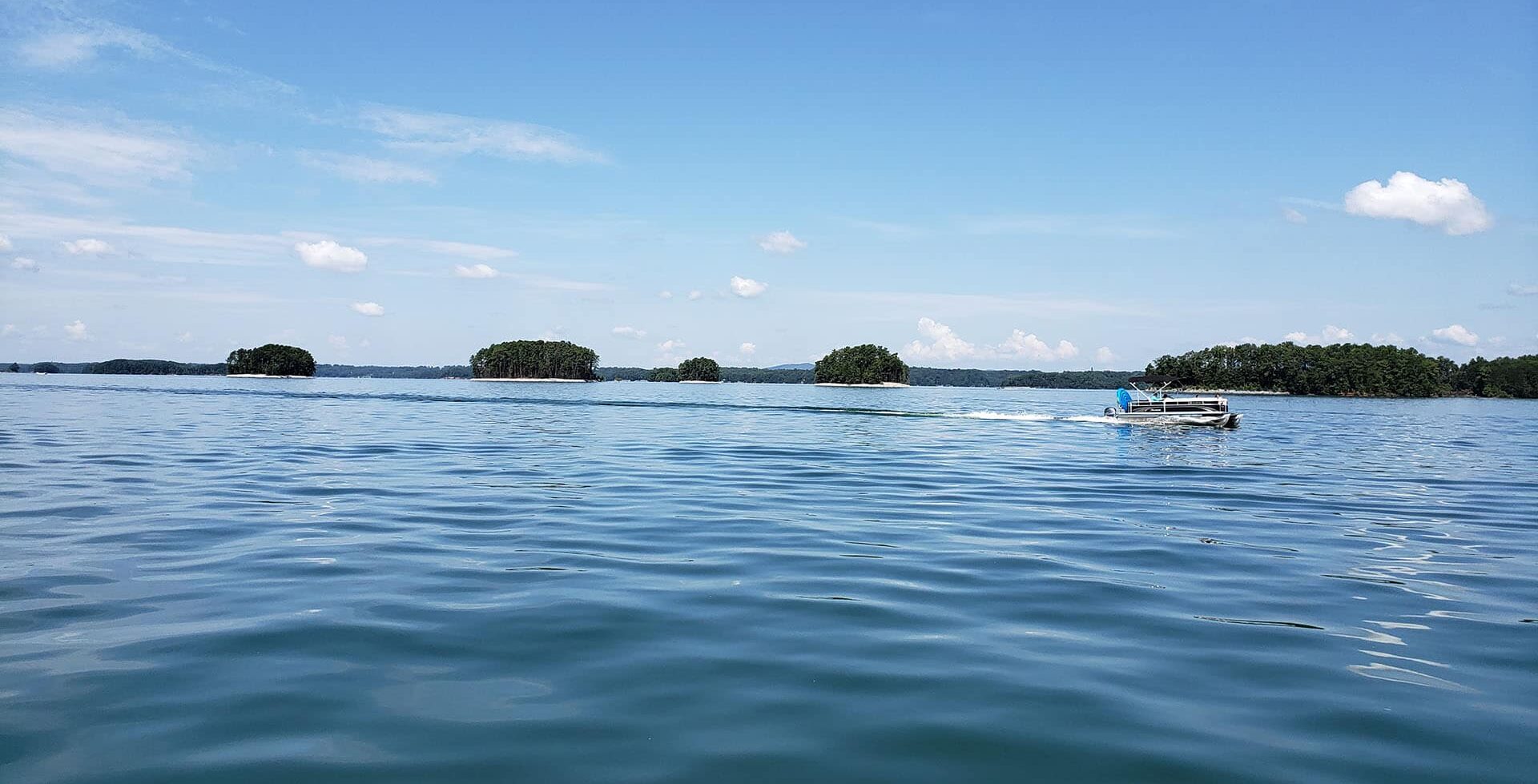 Boat floating across the lake on a sunny day